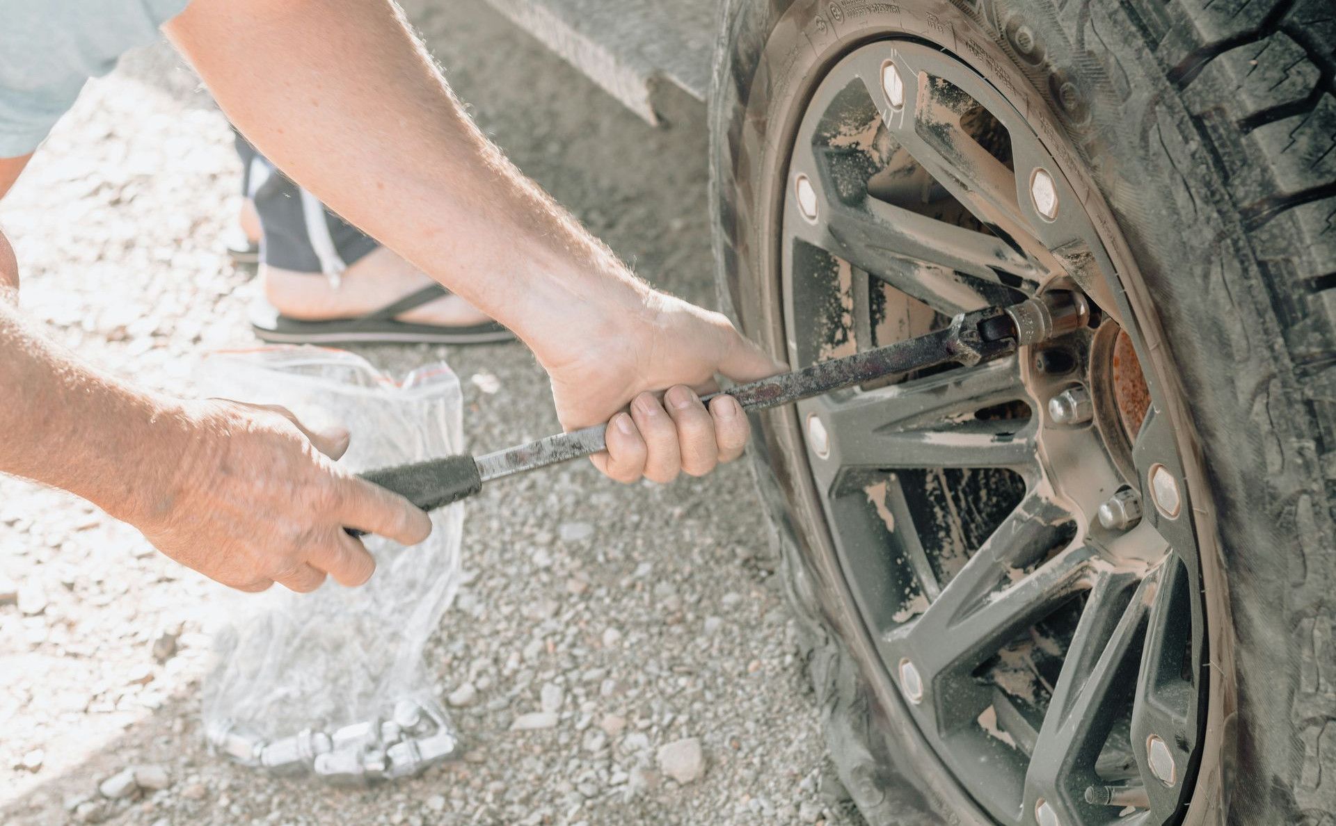 a man working on a tire with a wrench